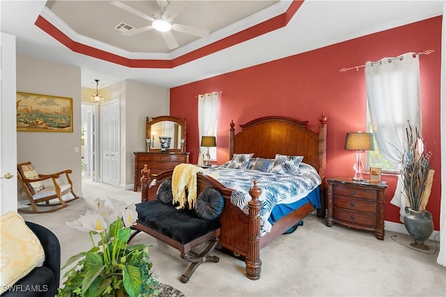 bedroom featuring light carpet, ceiling fan with notable chandelier, a raised ceiling, crown molding, and a closet