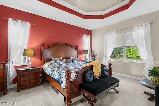 carpeted bedroom featuring ceiling fan, a raised ceiling, and ornamental molding