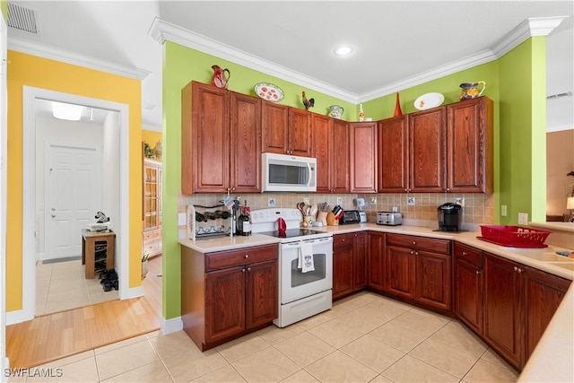 kitchen featuring light tile patterned flooring, white appliances, backsplash, and ornamental molding