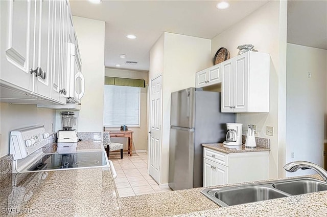 kitchen featuring light tile patterned floors, recessed lighting, a sink, white cabinets, and appliances with stainless steel finishes