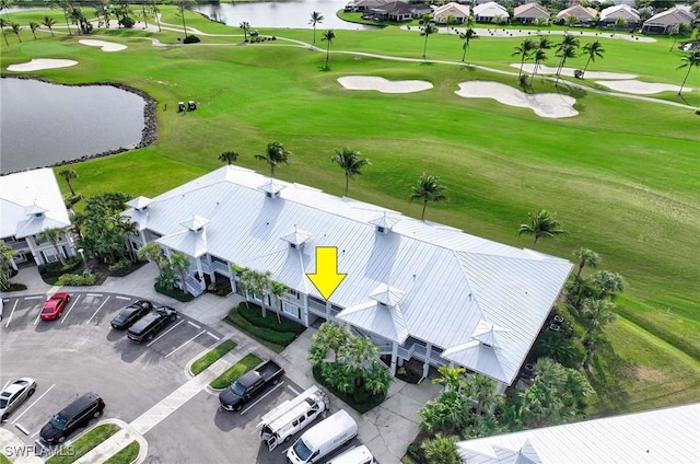 aerial view with golf course view and a water view