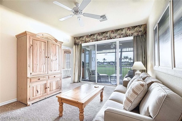 carpeted living area featuring a healthy amount of sunlight, baseboards, visible vents, and a ceiling fan