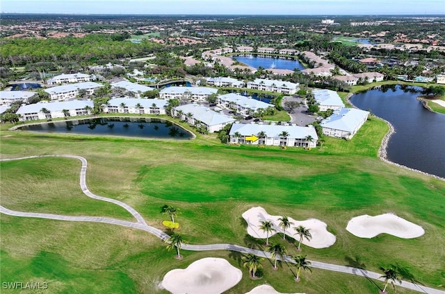 drone / aerial view with a water view, view of golf course, and a residential view