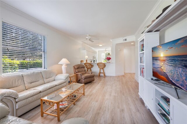 living room featuring ceiling fan, light wood-type flooring, and ornamental molding