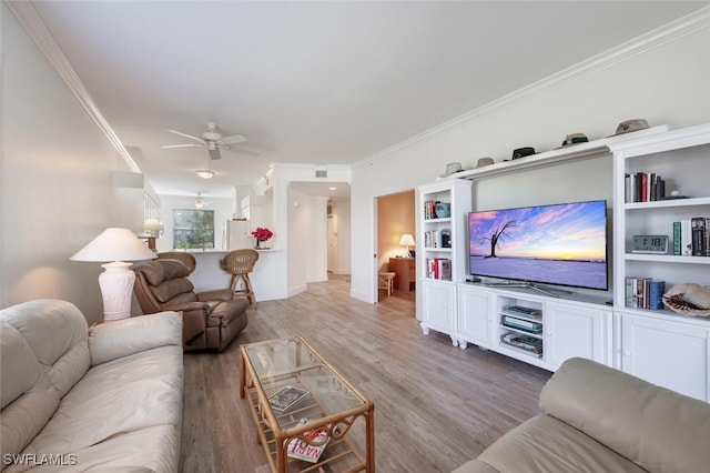 living room with hardwood / wood-style flooring, ceiling fan, and ornamental molding