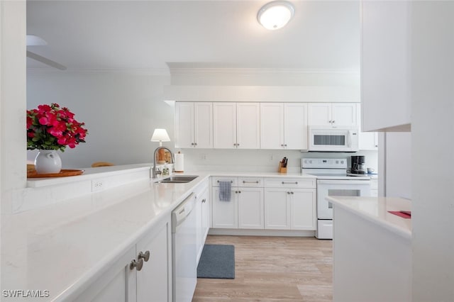 kitchen with light wood-type flooring, ornamental molding, white appliances, sink, and white cabinets