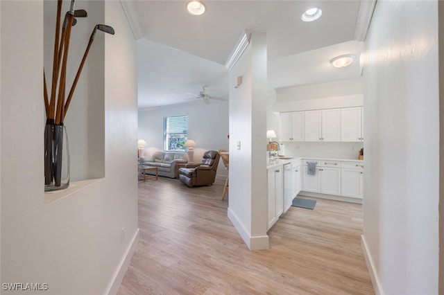 hall featuring light hardwood / wood-style floors, sink, and crown molding