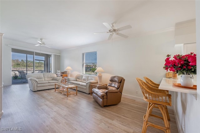 living room with light hardwood / wood-style floors, ornamental molding, and a wealth of natural light