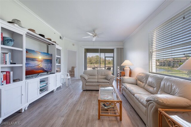 living room featuring light wood-type flooring, ceiling fan, and crown molding