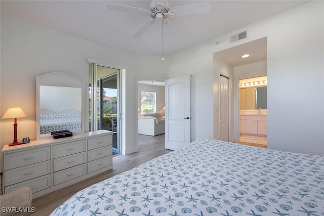 bedroom featuring connected bathroom, light hardwood / wood-style flooring, ceiling fan, and sink