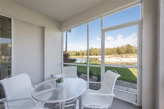 sunroom featuring a water view