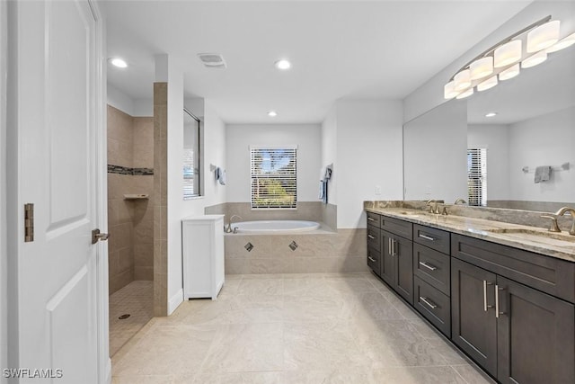 bathroom with tile patterned floors, vanity, and shower with separate bathtub