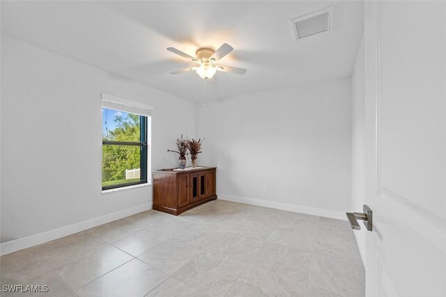 spare room featuring ceiling fan and light tile patterned flooring