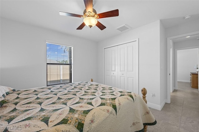 bedroom featuring ceiling fan, a closet, and light tile patterned flooring