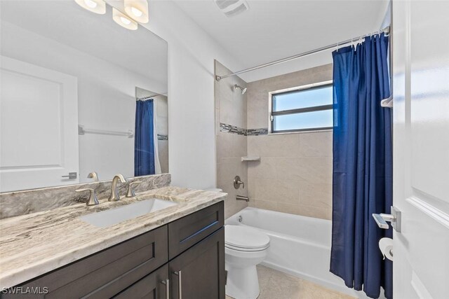 full bathroom with tile patterned floors, vanity, toilet, and shower / bath combo with shower curtain