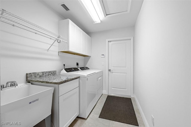 clothes washing area with cabinets, washer and clothes dryer, and sink