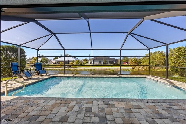 view of swimming pool with glass enclosure, a water view, and a patio