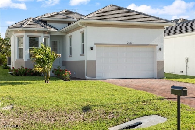 2537 Linda Dr, Naples, FL 34112 - view of front of property with decorative driveway, an attached garage, a tile roof, and stucco siding