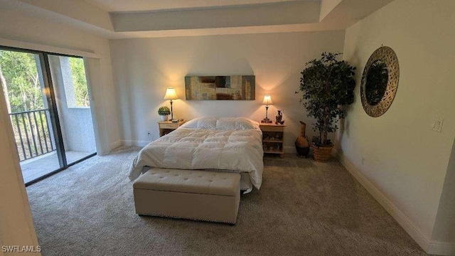 carpeted bedroom featuring a raised ceiling and access to exterior