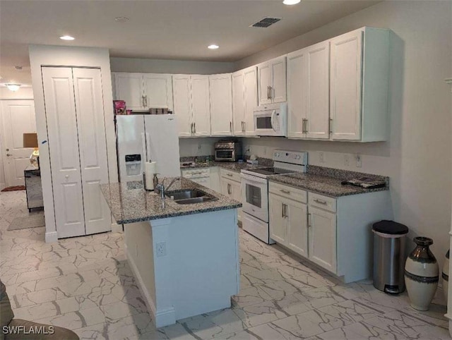 kitchen featuring white cabinets, white appliances, sink, and a kitchen island with sink