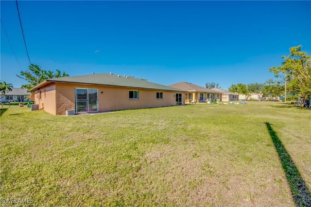 back of property featuring a lawn and central AC unit