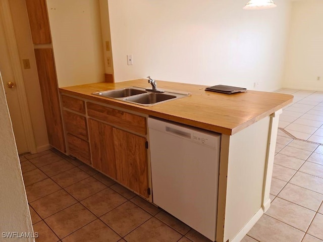 kitchen featuring sink, light tile patterned floors, and white dishwasher