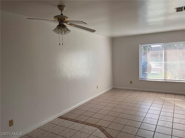 empty room with ceiling fan and light tile patterned flooring