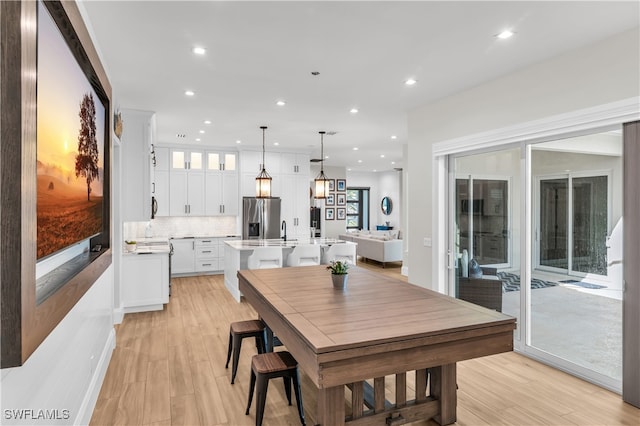 dining area with light wood-type flooring and sink