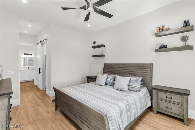 bedroom featuring connected bathroom, light hardwood / wood-style flooring, and ceiling fan