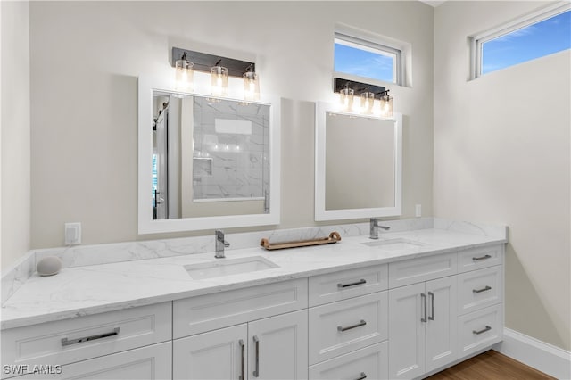 bathroom featuring hardwood / wood-style floors, vanity, and walk in shower