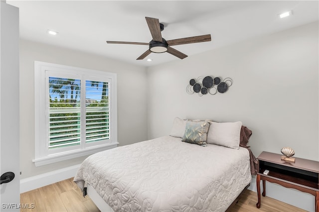 bedroom featuring multiple windows, wood-type flooring, and ceiling fan