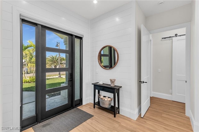 entryway with light hardwood / wood-style floors and a barn door