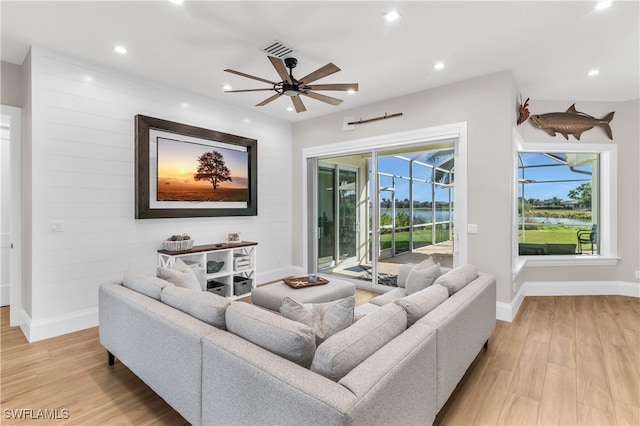 living room with ceiling fan and light hardwood / wood-style floors