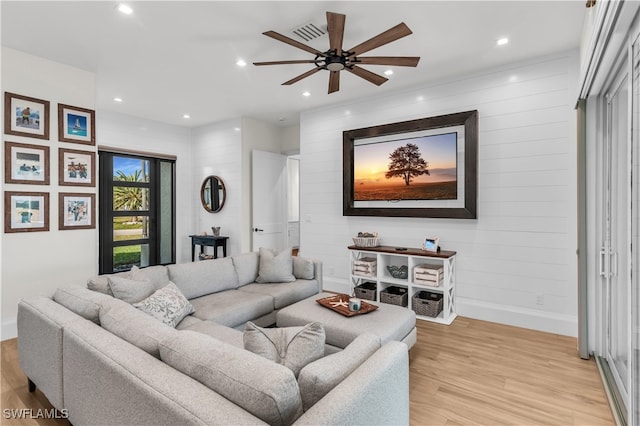 living room with light hardwood / wood-style flooring and ceiling fan