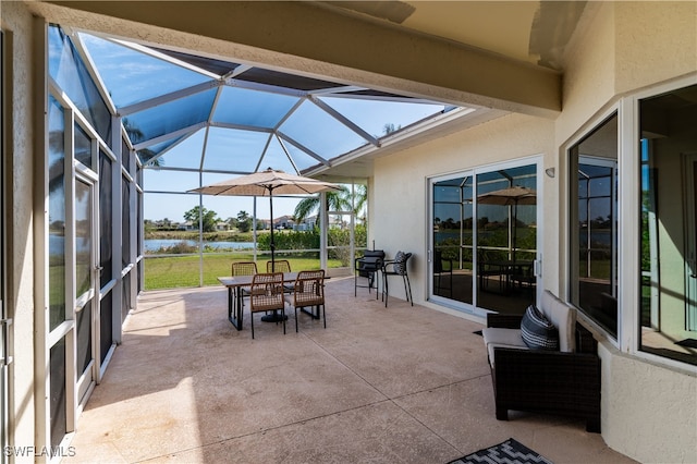 view of patio with a water view and a lanai