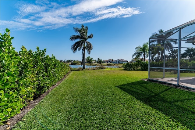 view of yard featuring a lanai and a water view