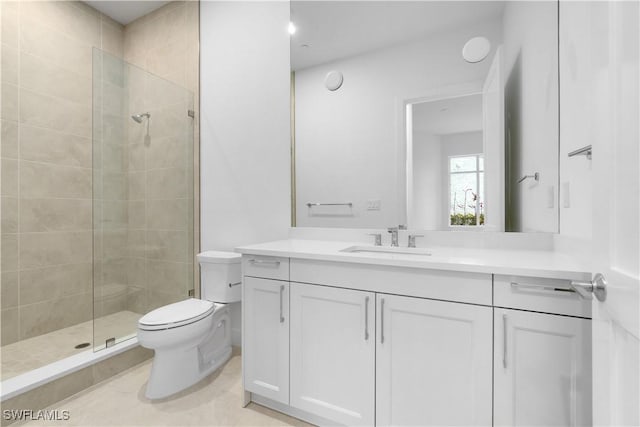 bathroom with toilet, vanity, and a tile shower