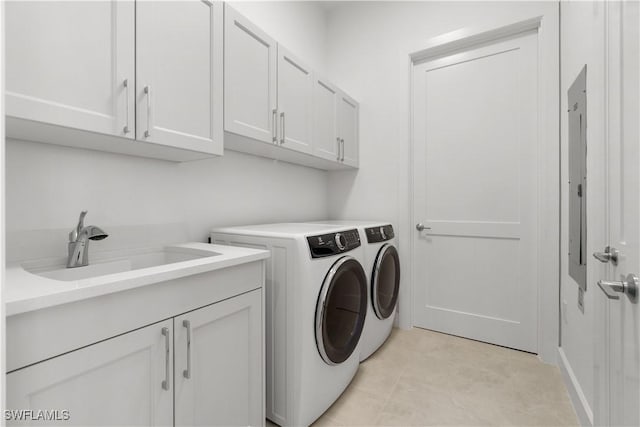 laundry room featuring light tile patterned floors, sink, separate washer and dryer, and cabinets