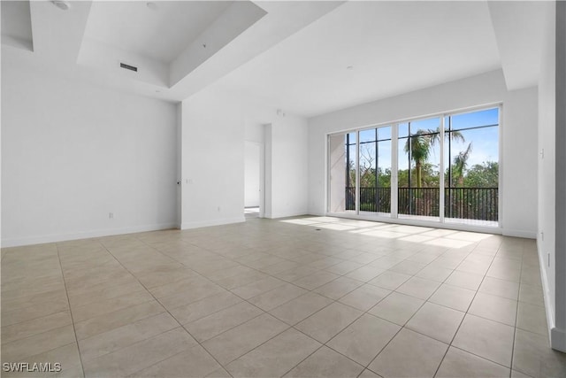 spare room featuring light tile patterned floors and a tray ceiling