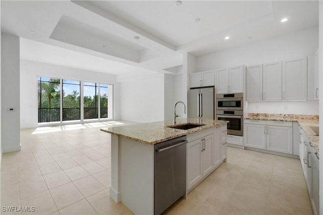 kitchen featuring sink, white cabinetry, appliances with stainless steel finishes, and a kitchen island with sink