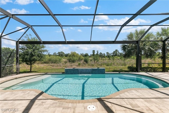 view of swimming pool with pool water feature, a lanai, and a patio