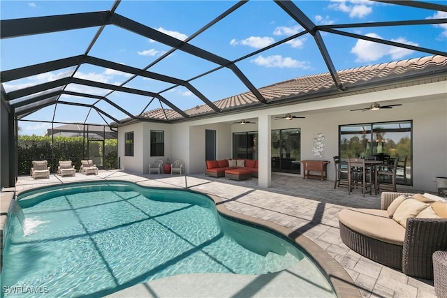 view of swimming pool with a patio, an outdoor hangout area, glass enclosure, and ceiling fan