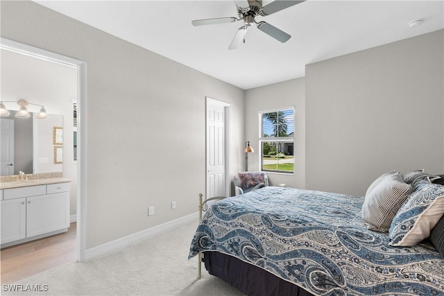 carpeted bedroom with ceiling fan, sink, and ensuite bath