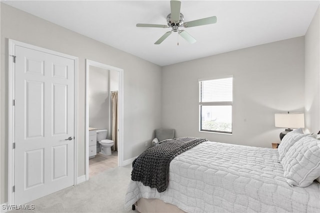 bedroom with light carpet, ensuite bathroom, and ceiling fan