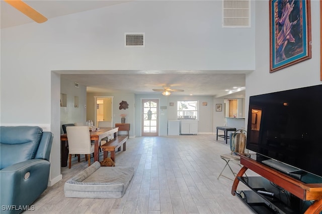 living room with ceiling fan and light hardwood / wood-style flooring