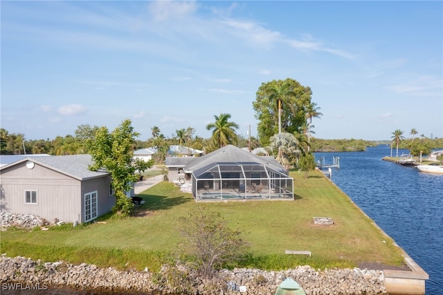 back of property featuring a lawn, a lanai, and a water view