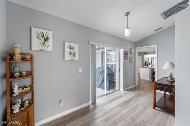 interior space featuring light wood-type flooring and vaulted ceiling