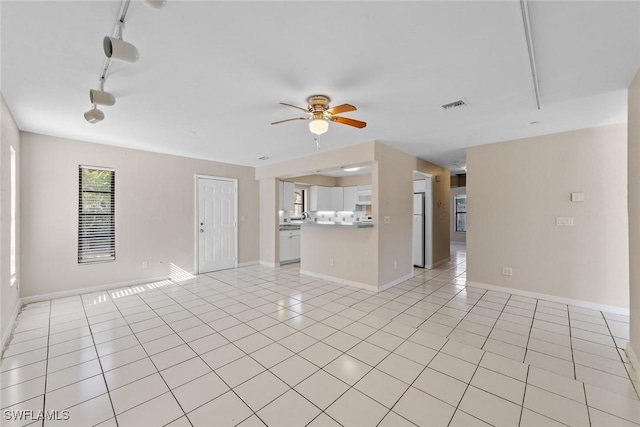 unfurnished living room featuring track lighting, visible vents, baseboards, ceiling fan, and light tile patterned flooring