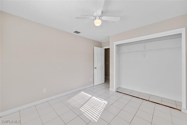 unfurnished bedroom with visible vents, a ceiling fan, a closet, light tile patterned floors, and baseboards