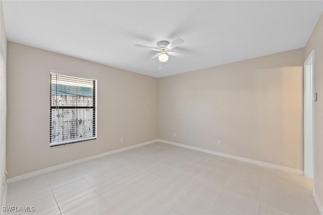 empty room featuring light tile patterned floors, baseboards, and ceiling fan